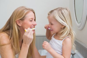 Mother and daughter brushing teeth